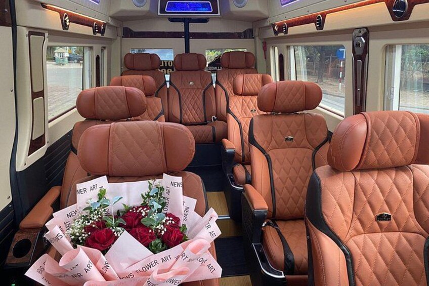 A train interior with rows of orange quilted seats and a bouquet of flowers on the left. 5