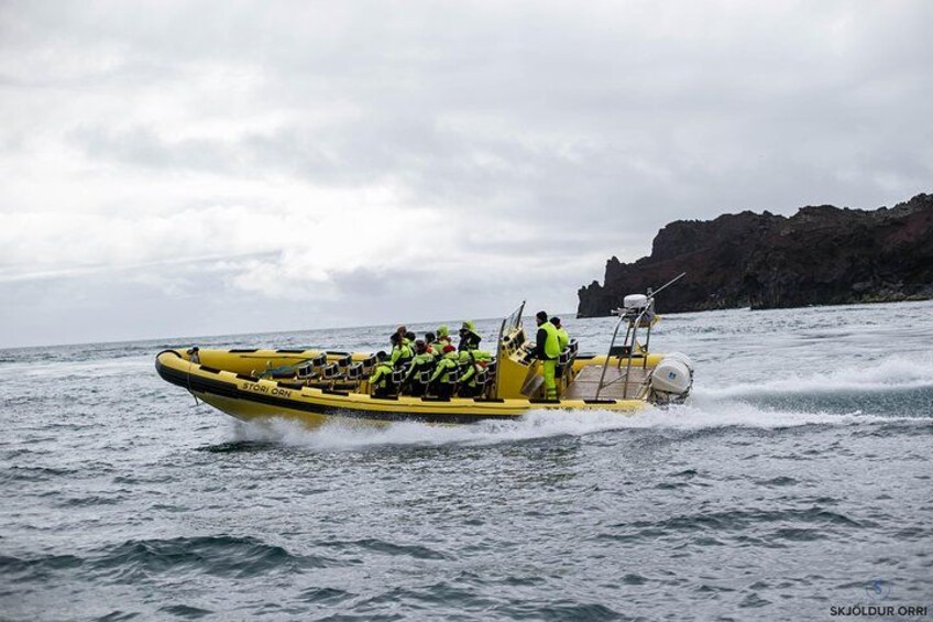 A yellow boat with people wearing life jackets on the water. 2