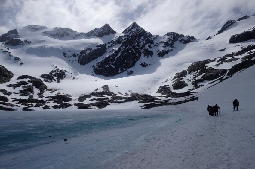 A snowy mountain landscape with a group of people walking on a snow-covered path. 2