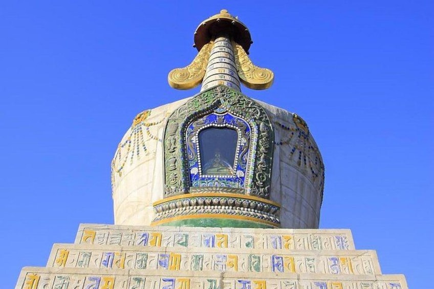 A domed structure with intricate patterns and a central window, set against a clear blue sky. 3