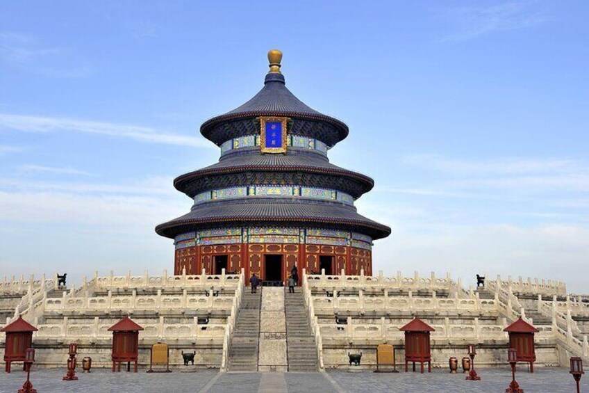 A traditional Chinese building with a multi-tiered roof, a large staircase leading up to it, and a stone wall with lanterns in the foreground. 5