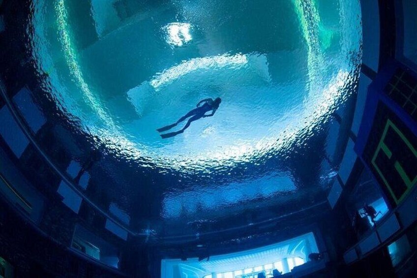 A diver in a large, transparent spherical structure with a blue interior. 2