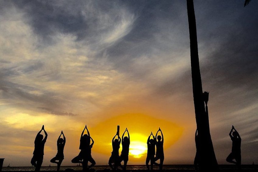Siluetas de personas en posturas de yoga al atardecer. 2