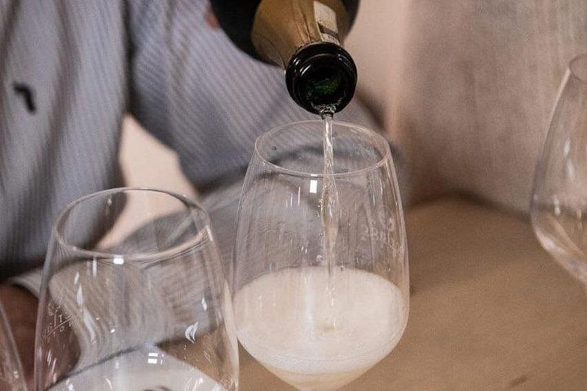 A person pouring a liquid into a glass. 3