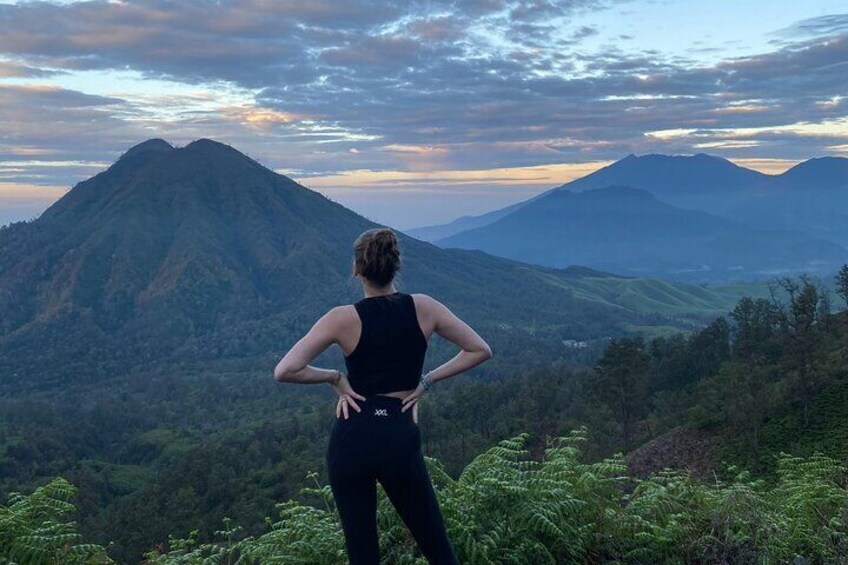 A person standing on a hill overlooking a mountainous landscape. 3
