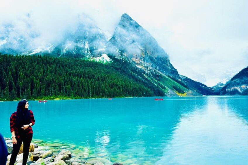 A lake with clear water, surrounded by mountains and dense forest. 1
