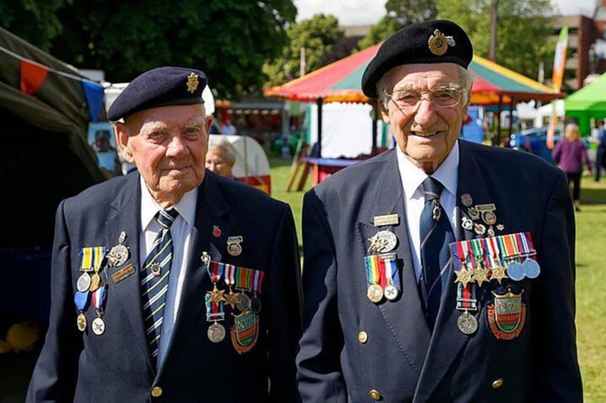 Two men in military uniforms with medals, standing outdoors at an event. 3