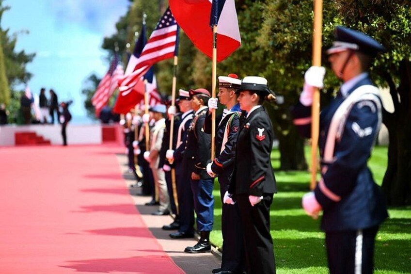 A military ceremony with personnel in uniform holding flags. 2