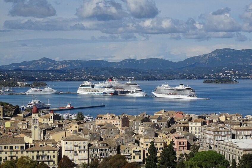 Une ville côtière où des navires de croisière sont amarrés dans un port, entourée de montagnes et d’immeubles d’habitation. 5