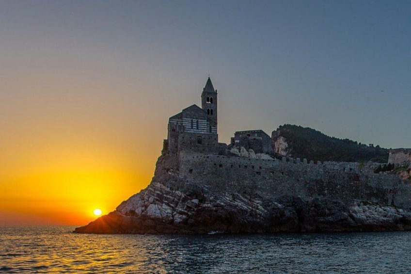 A coastal fortress with a tower, sunset, and rocky cliffs. 4