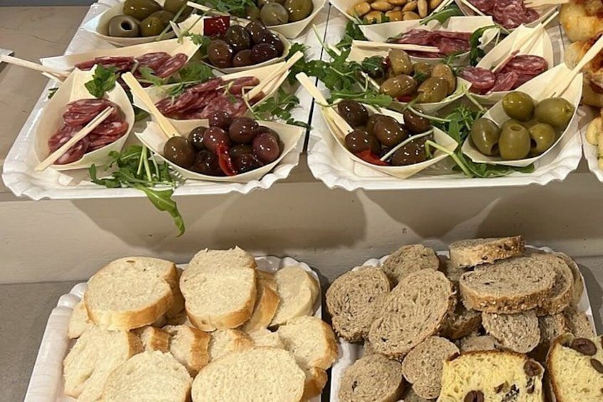 A variety of food items including bread, olives, and meats arranged on trays. 3