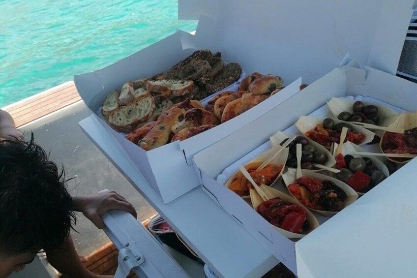 A food box with various snacks and bread on a boat. 4