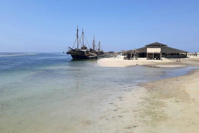 A beach with a ship and a building. 2