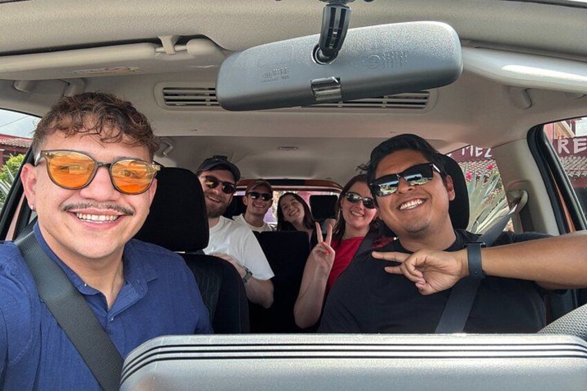 A group of people inside a vehicle with a sun visor and a seatbelt. 1