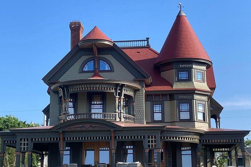 A large, ornate Victorian-style house with a red roof and multiple towers. 2
