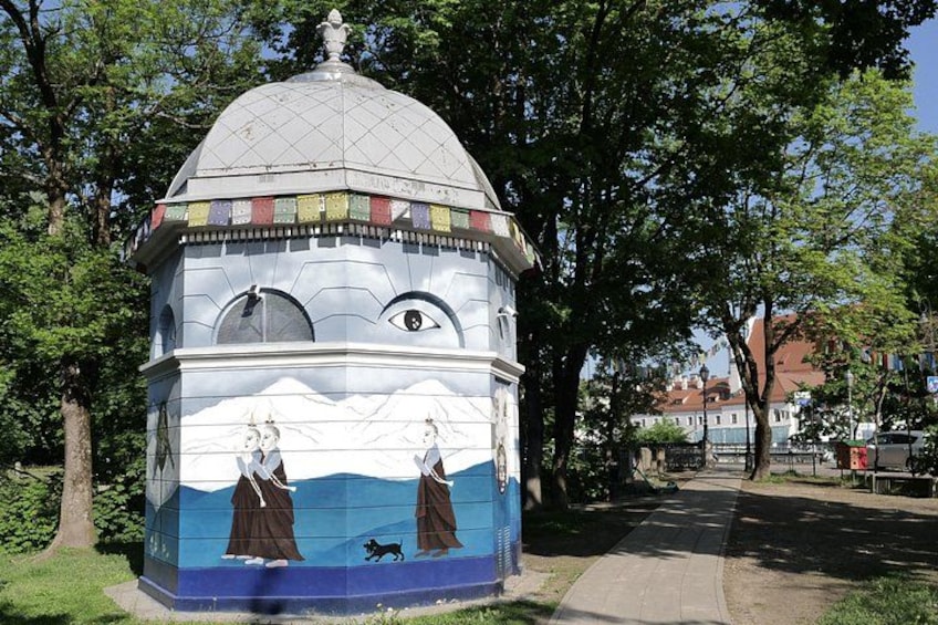 A colorful mural on a building with a dome, depicting figures and a landscape. 5