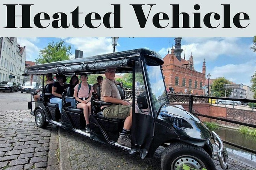 A heated vehicle with passengers on a cobblestone street. 2