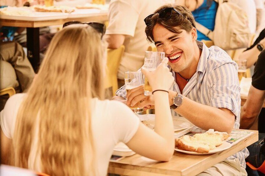 Dos personas sentadas a una mesa con un plato de comida y un vaso de bebida. 3