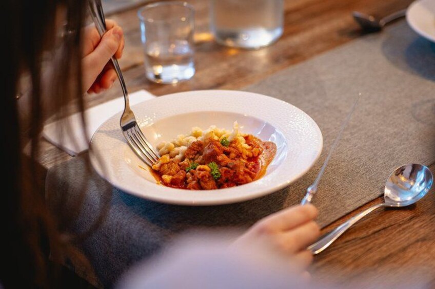 Una persona comiendo pasta con un tenedor sobre una mesa. 4