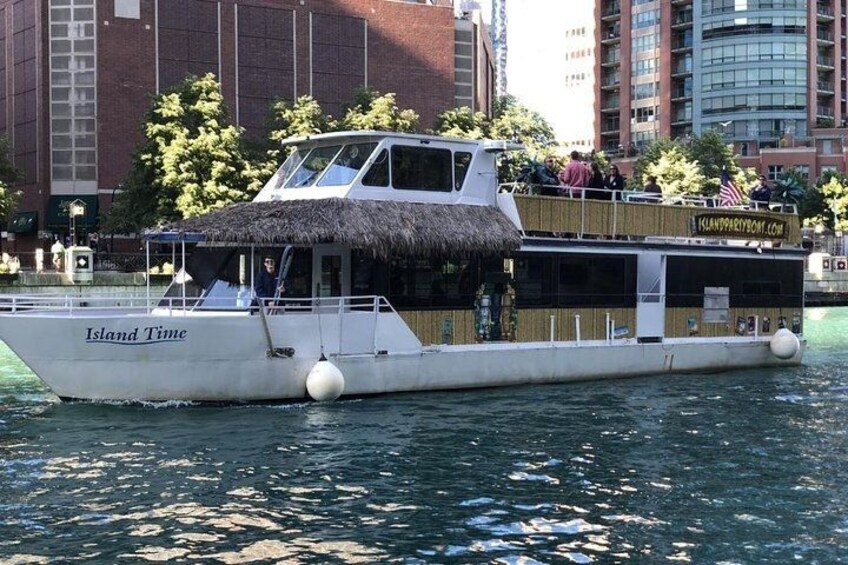 A boat named 'Island Time' with a thatched roof, passengers, and a cityscape in the background. 2