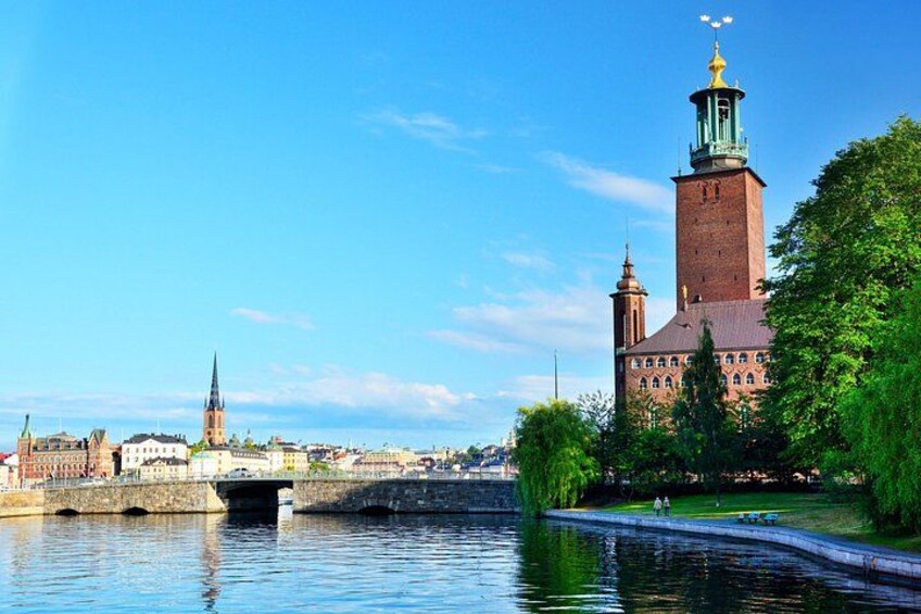 En flod med en bro, en kyrka med ett högt torn och en spira i bakgrunden. 3