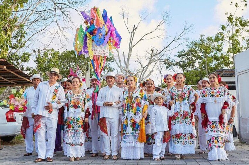 A group of people in traditional white and colorful attire posing for a photo. 3