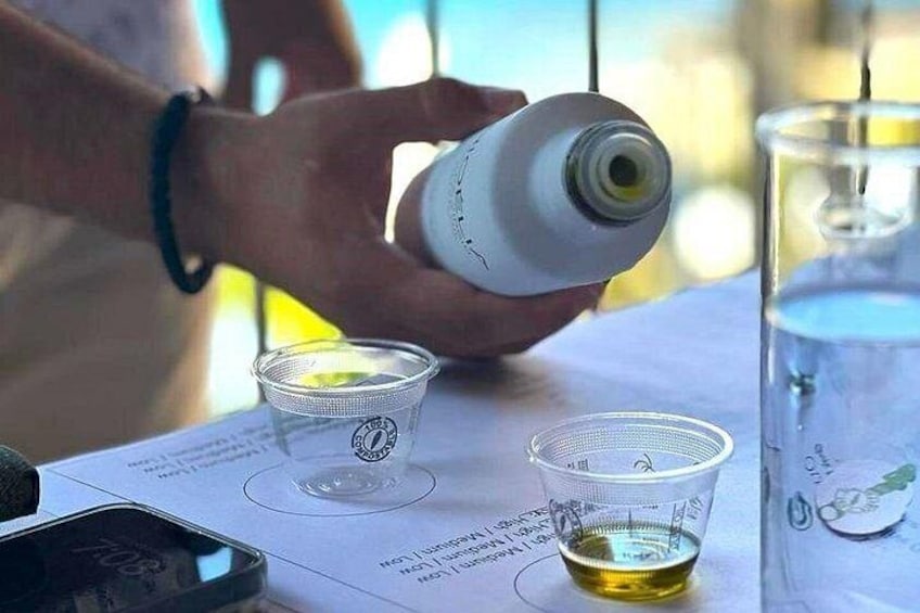 Una persona vertiendo un líquido de una botella en un vaso pequeño. 3