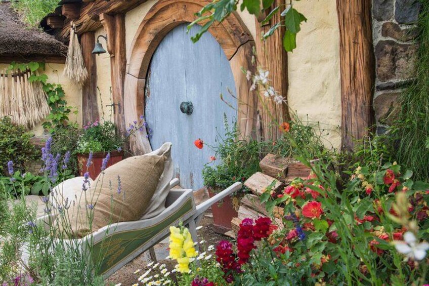 A Hobbit-style door, a thatched roof, and a garden with various flowers. 3