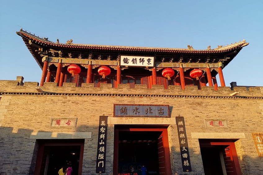 Un edificio tradicional chino con techo de tejas, faroles rojos y caracteres chinos en las paredes. 5