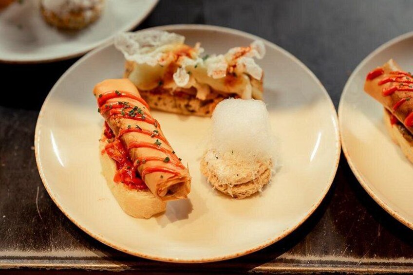 A plate with a rolled pastry, a dessert, and a piece of cake. 3