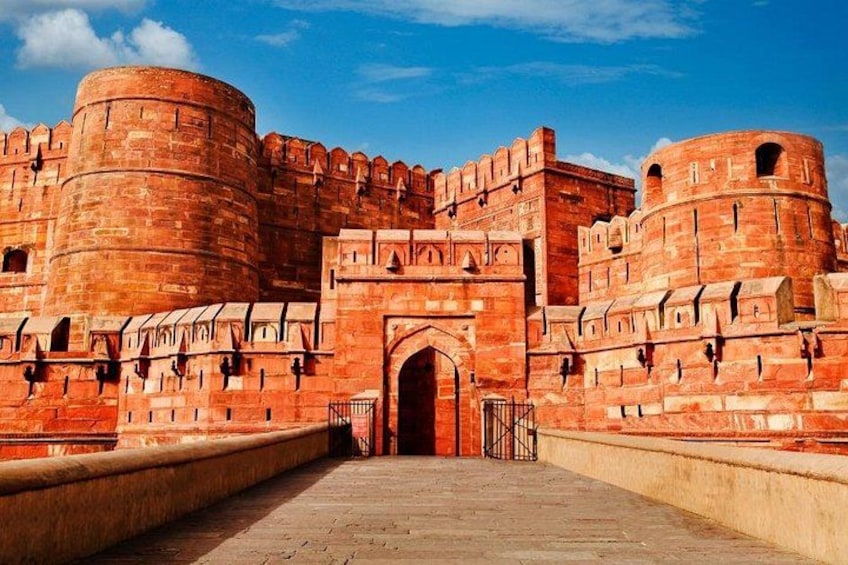 A large, historic red brick fort with a central gateway and multiple towers. 3
