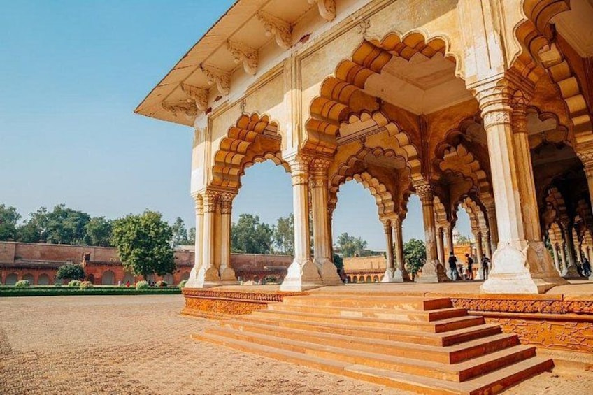 A historical building with arches and columns, surrounded by a landscaped area with steps leading up to it. 5