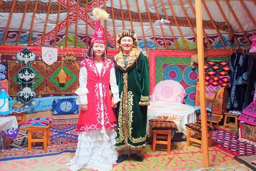 A traditional yurt with colorful textiles and a person in a red and white costume. 2