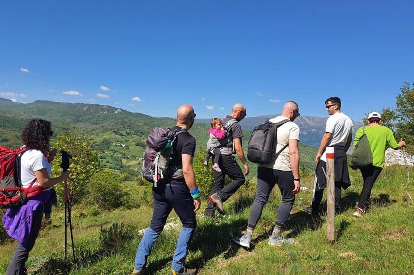 A group of hikers on a trail with a mountainous landscape in the background. 2