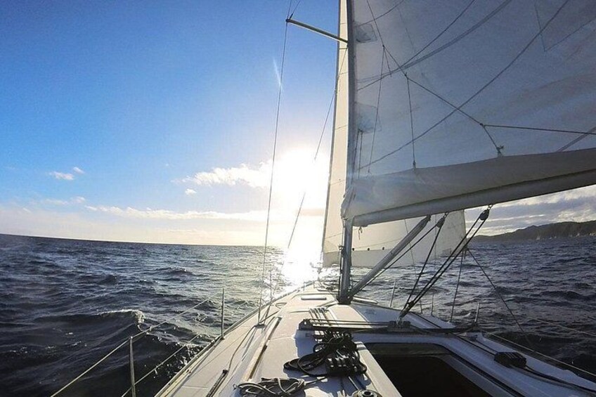 A sailboat with a partially unfurled sail on the water. 3