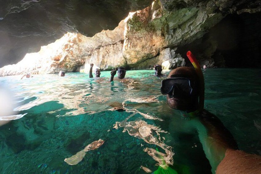 Eine Person schnorchelt in einer klaren Unterwasserhöhle mit steinernen Wänden. 3