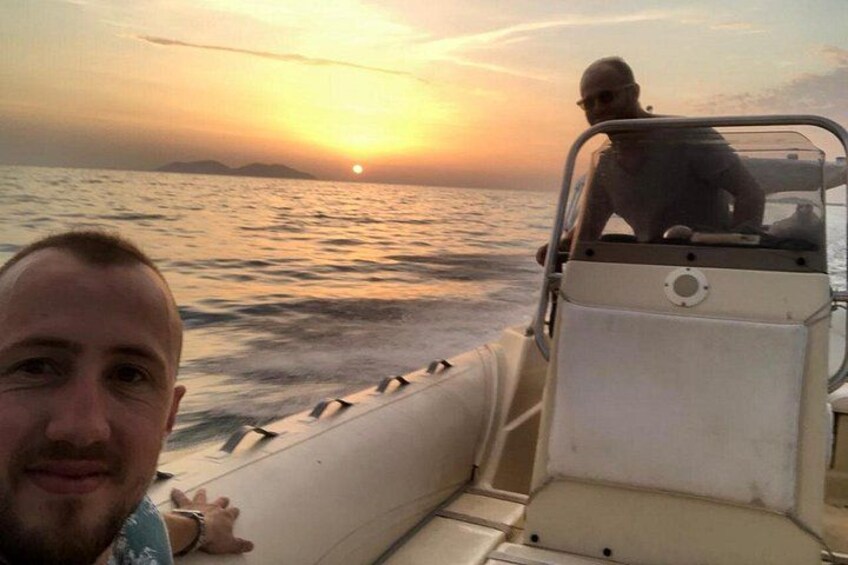 Ein Boot auf dem Wasser, im Hintergrund ein Sonnenuntergang. 2