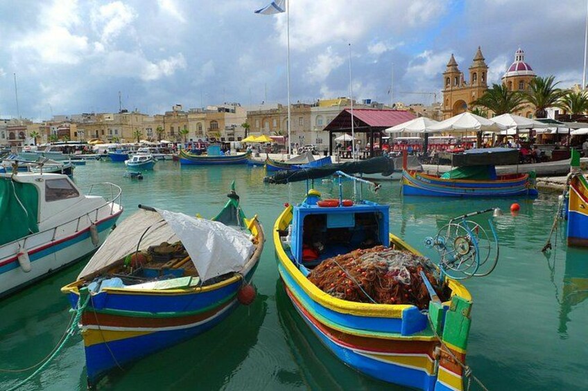 A marina with colorful boats docked, a building with a dome, and a clear sky. 1