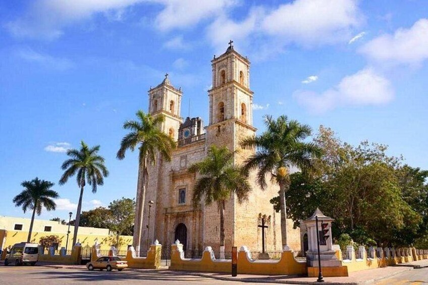A historic church with two towers, palm trees, and a clear blue sky. 5