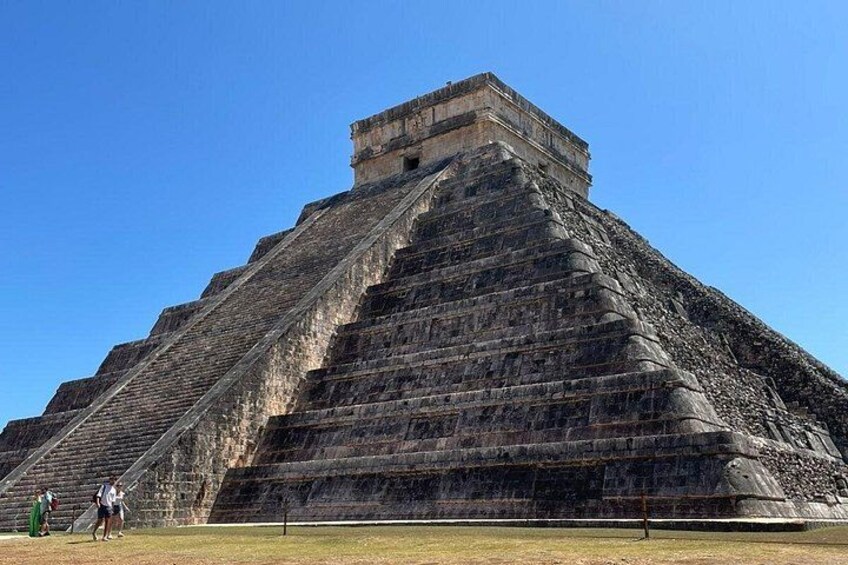 A large pyramid with multiple levels, surrounded by a clear sky. 2