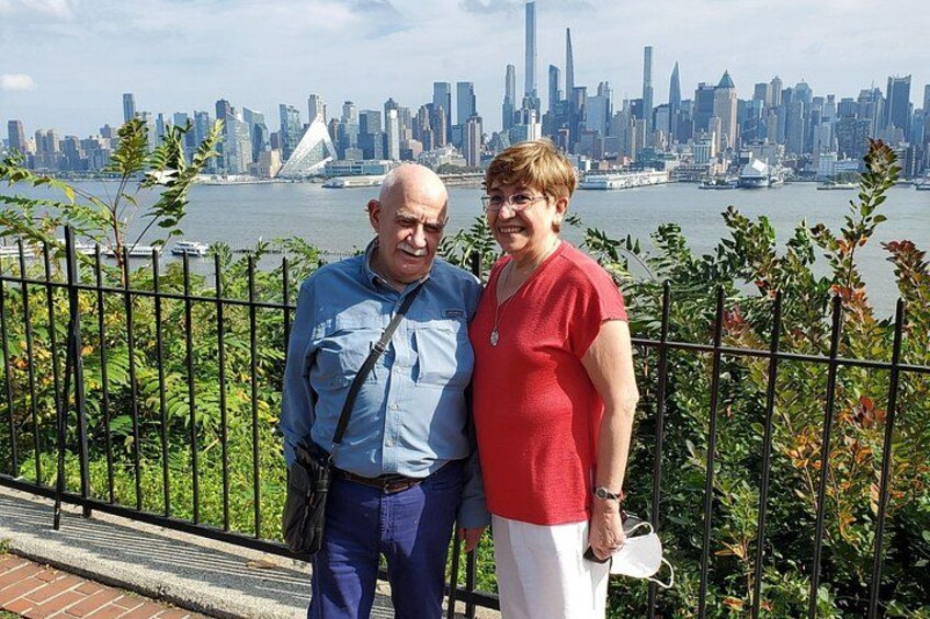 Two people standing in front of a city skyline with a bridge in the background. 5