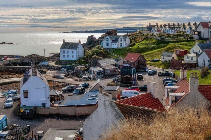 A coastal town with houses, a dock, and a view of the sea. 4