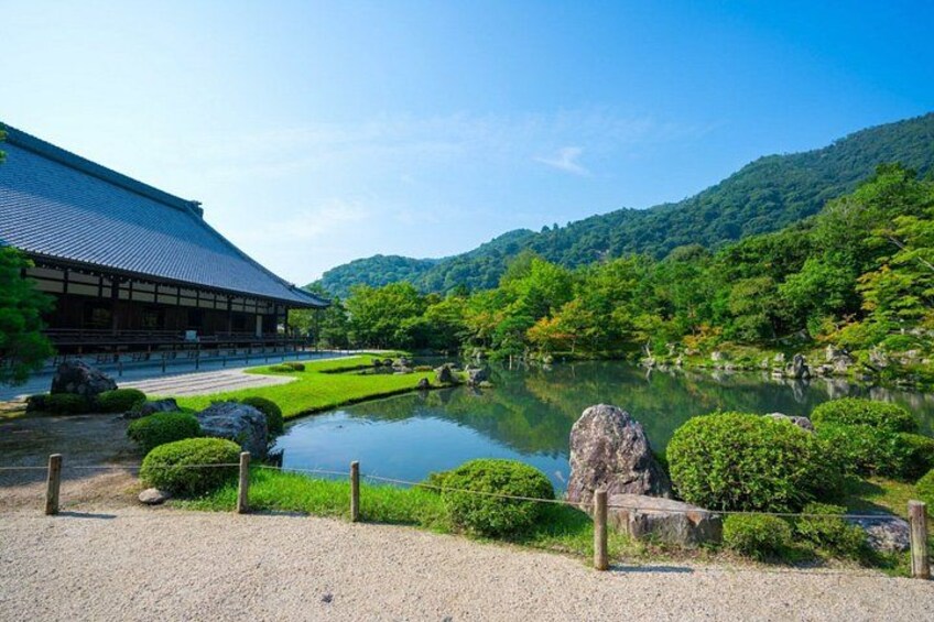 A traditional Japanese building, a pond, and a mountainous landscape. 2