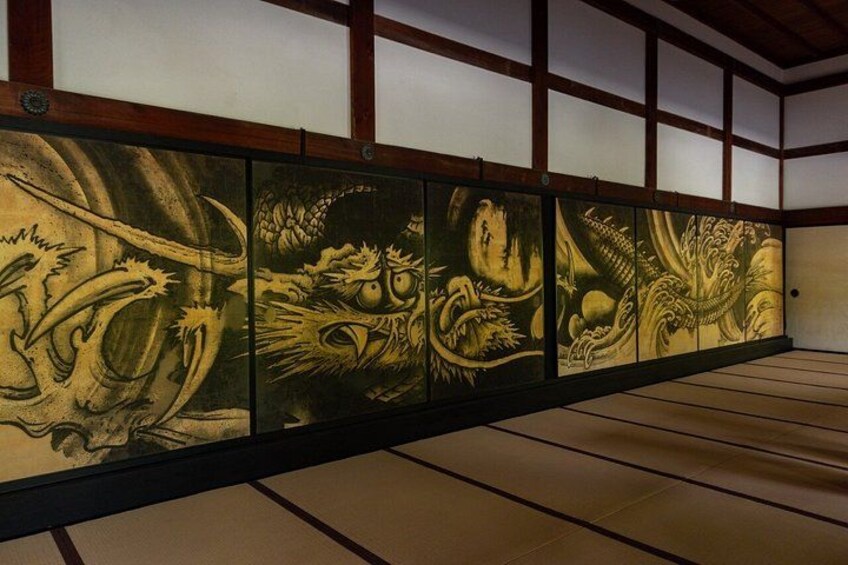 A traditional Japanese room with tatami flooring and a series of paintings depicting mythical creatures. 3