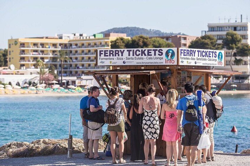 A ferry ticket booth with people standing in line. 2