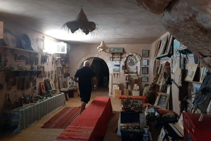 A cluttered room with shelves, a red mat, and various items on the walls. 4