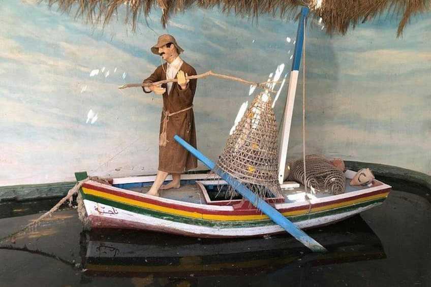 A model of a traditional boat with a person standing on it, a fishing net, and a small structure on the back. 2