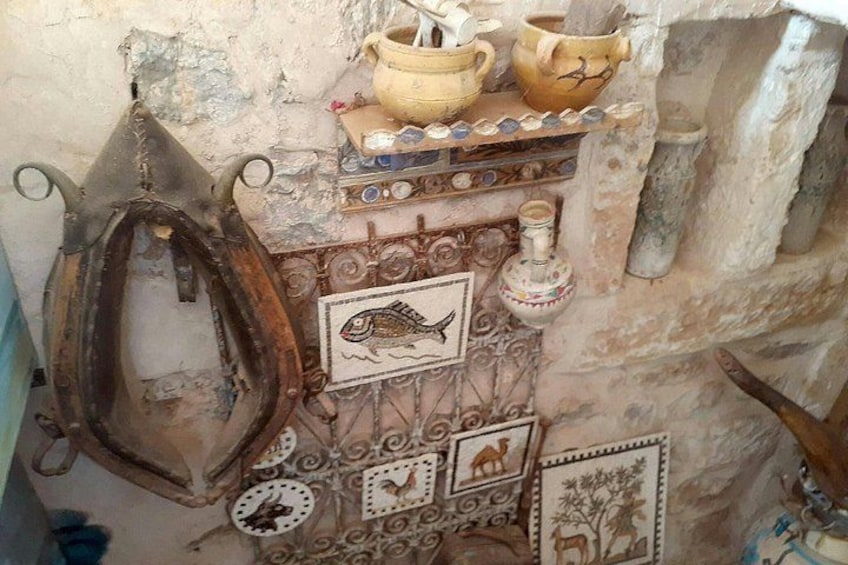 A rustic kitchen with a hanging pot rack, decorative plates, and a fish illustration. 5