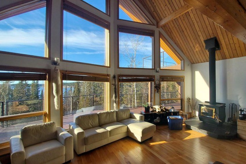 A spacious living room with a large sectional sofa, a fireplace, and large windows. 1