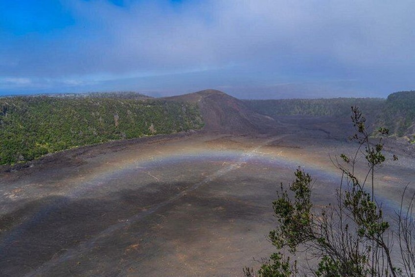 A landscape with a rainbow over a barren area, surrounded by green hills. 5